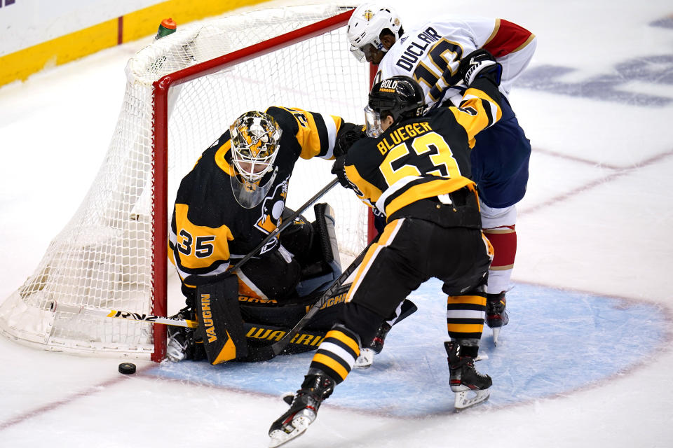 Pittsburgh Penguins goaltender Tristan Jarry (35) blocks a shot by Florida Panthers' Anthony Duclair (10) with Teddy Blueger (53) defending during the first period of an NHL hockey game in Pittsburgh, Tuesday, March 8, 2022. (AP Photo/Gene J. Puskar)