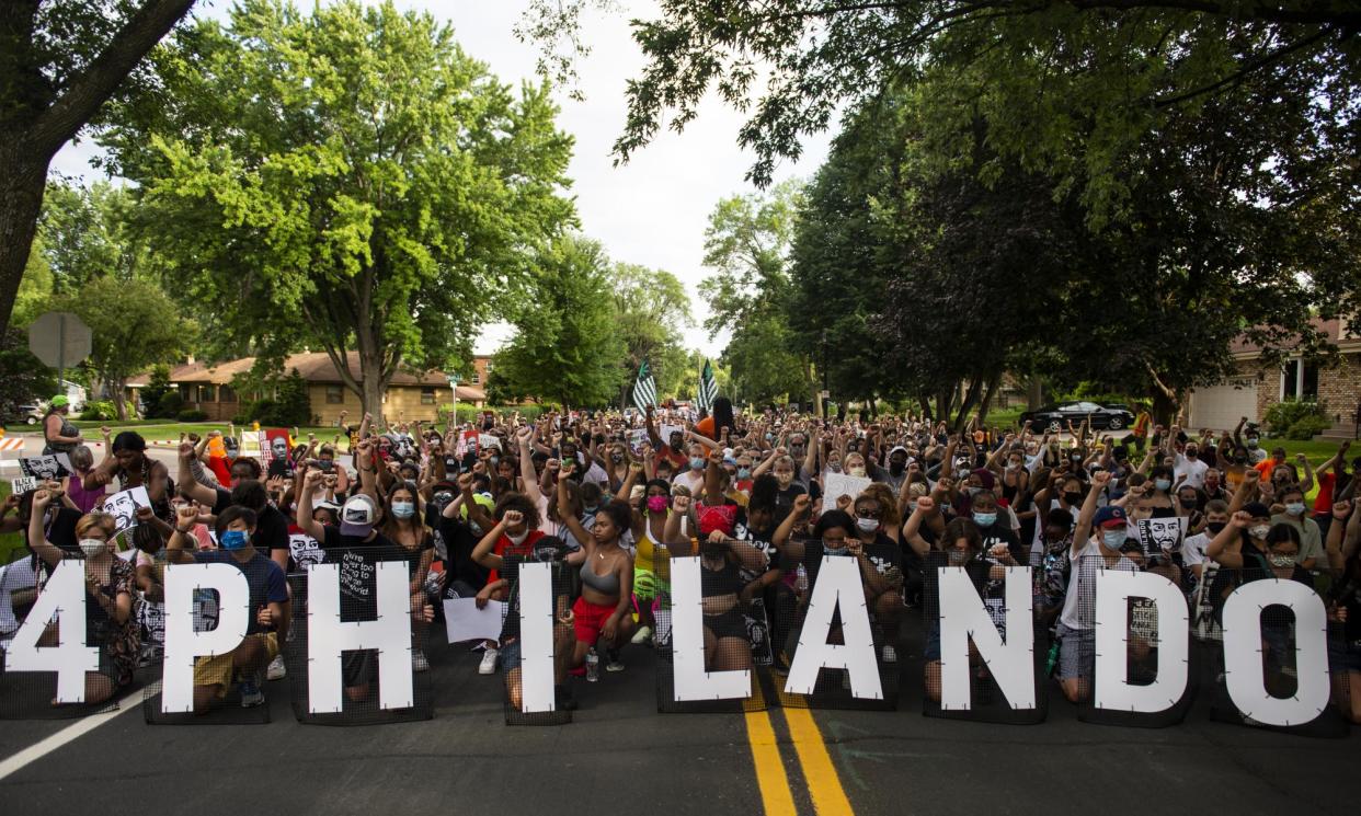 <span>Demonstrators take a knee and hold up a fist as they march in honor of Philando Castile in 2020 in St Anthony, Minnesota.</span><span>Photograph: Stephen Maturen/Getty Images</span>