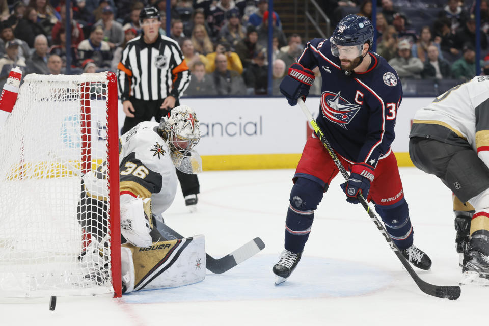 Vegas Golden Knights' Logan Thompson, left, makes a save against Columbus Blue Jackets' Boone Jenner during the second period of an NHL hockey game on Monday, Nov. 28, 2022, in Columbus, Ohio. (AP Photo/Jay LaPrete)