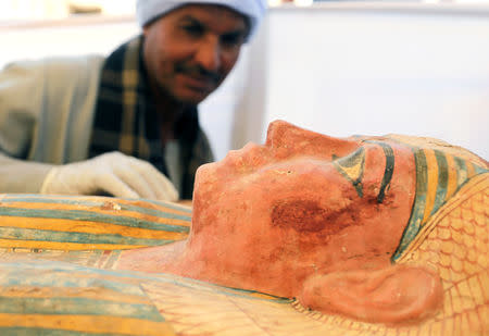 An Egyptian worker inspecting a sarcophagus outside a newly discovered pharaonic tomb "Shedsu Djehuty" in Luxor, Egypt April 18, 2019. REUTERS/Mohamed Abd El Ghany