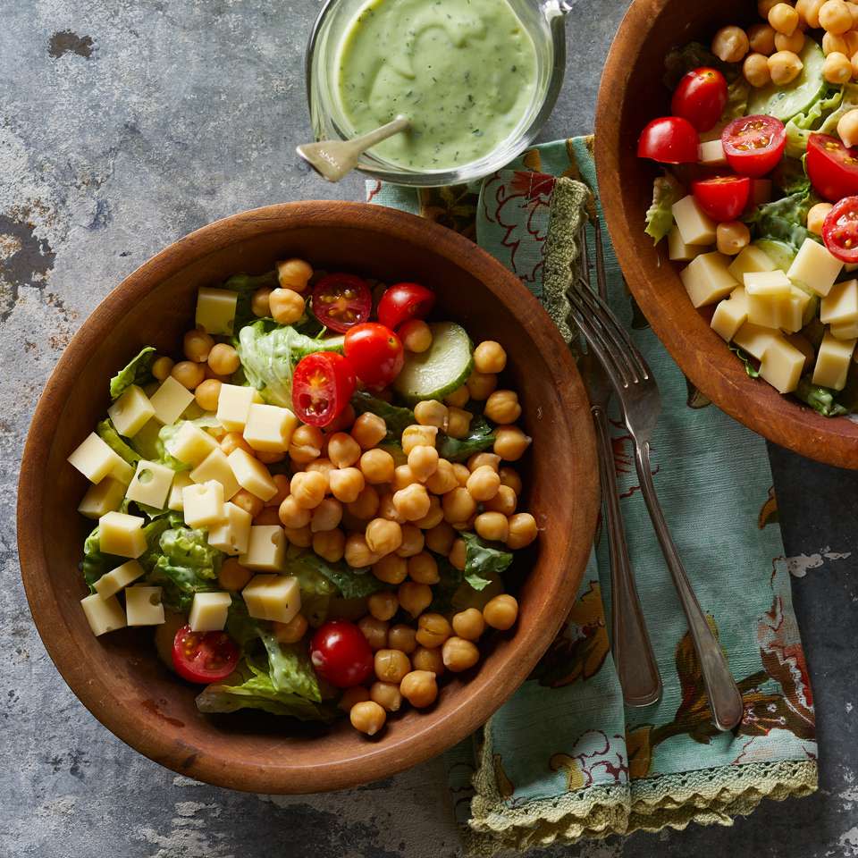 <p>In this cucumber, tomato, Swiss cheese and chickpea salad recipe, a healthy green goddess dressing is made from avocado, buttermilk and herbs. The extra dressing is delicious served with grilled vegetables.</p>