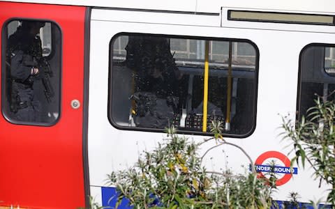 Armed British police officers walk through the carriage of a London underground tube carriage - Credit: DANIEL LEAL-OLIVAS/AFP