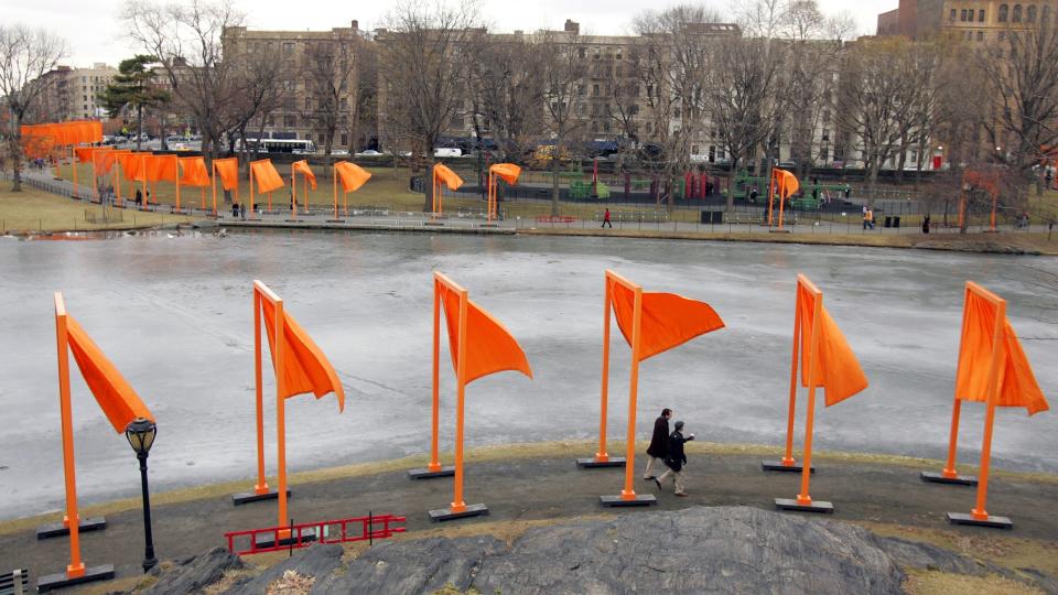 FILE - In this Feb. 12, 2005, file photo, pedestrians walk along the edge of Harlem Meer under "The Gates" project, by artists Christo and Jeanne-Claude, in New York's Central Park. Christo, known for massive, ephemeral public arts projects, has died. His death was announced Sunday, May 31, 2020, on Twitter and the artist's web page. He was 84. (AP Photo/Julie Jacobson, File)