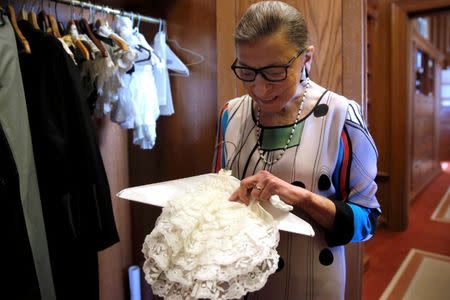 U.S. Supreme Court Justice Ruth Bader Ginsburg shows the many different collars (jabots) she wears with her robes, in her chambers at the Supreme Court building in Washington, U.S. June 17, 2016. REUTERS/Jonathan Ernst