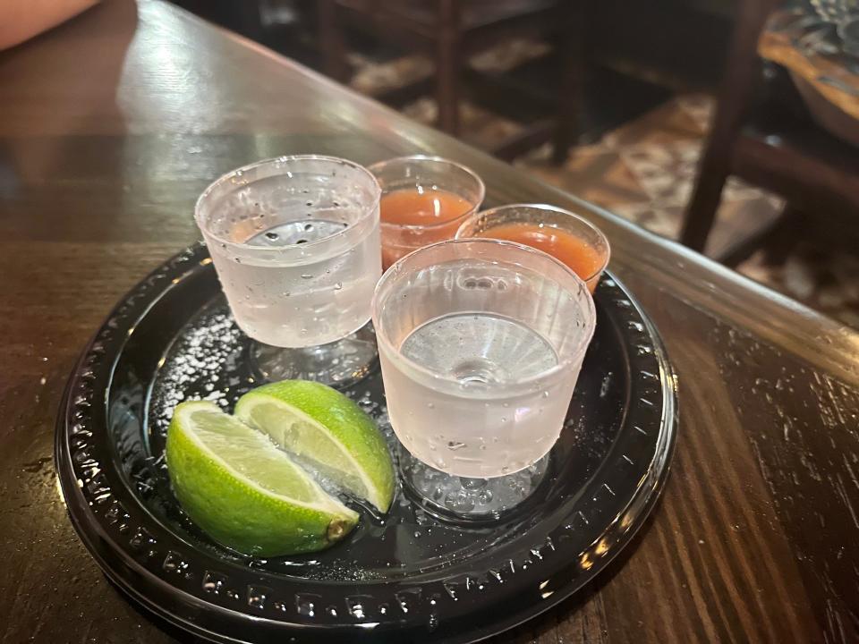 A platter of two shots, chasers, and limes.