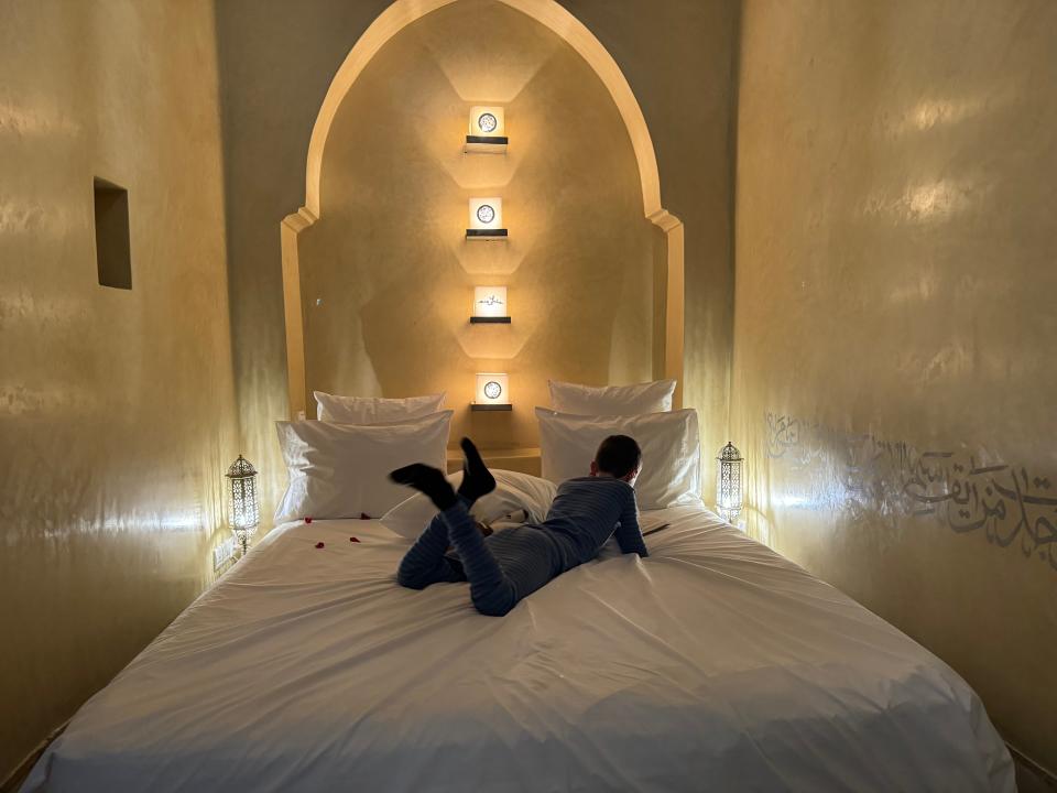 jamie's son siting on a bed in a room at anayela riad in morocco
