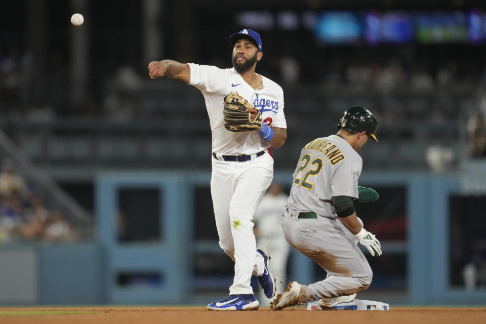 Los Angeles Dodgers second baseman Amed Rosario, left, throws to first after forcing out Oakland Athletics' Ramon Laureano (22) during the ninth inning of a baseball game in Los Angeles, Wednesday, Aug. 2, 2023. Shea Langeliers was safe at first. (AP Photo/Ashley Landis)