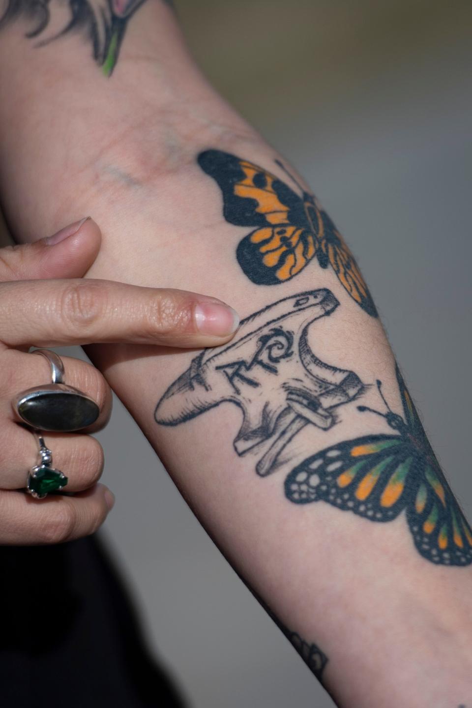 Krystal McMurray shows a tattoo of her husband, Ryan McMurray's, foundry mark during an interview at Rigden Farm Community Garden in Fort Collins, Colorado, on Saturday, March 26, 2022.