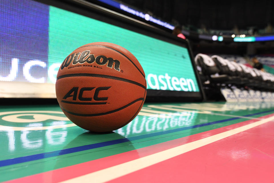 A basketball that says "ACC" sits on the court. 