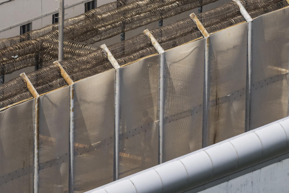 Jimmy Lai is silhouetted through a fence as he exercises at the Stanley prison in Hong Kong, Friday, Aug. 4, 2023. The Associated Press got a rare glimpse of the jailed 75-year-old publisher and prominent pro-democracy activist Lai. (AP Photo/Louise Delmotte)