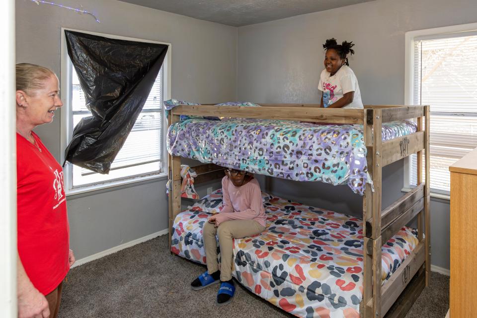 Aniyah, 8, and Aziyah, 13, try out their new bunk bed for the first time after it was assembled in their room by Sleep in Heavenly Peace-Oklahoma City volunteers.