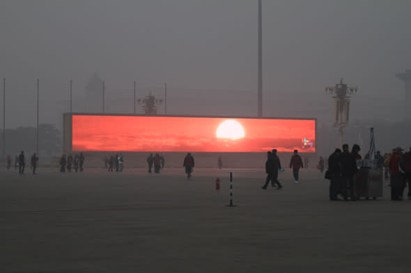 BEIJING, CHINA - JANUARY 16:  (CHINA OUT) The LED screen shows the rising sun on the Tiananmen Square which is shrouded with heavy smog on January 16, 2014 in Beijing, China. Beijing Municipal Government issued a yellow smog alert this morning.  (Photo by ChinaFotoPress/ChinaFotoPress via Getty Images)