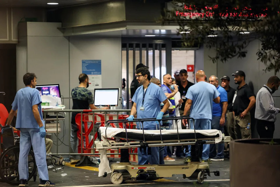 Hospital workers around an empty stretcher (Mohamed Azakir / Reuters)