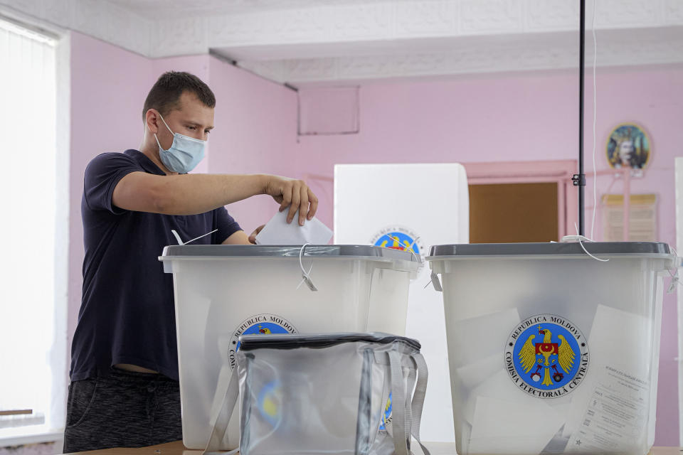 A man casts his vote in a snap parliamentary election, in Chisinau, Moldova, Sunday, July 11, 2021. Moldovan citizens vote in a key snap parliamentary election that could decide whether the former Soviet republic fully embraces pro-Western reform or prolongs a political impasse with strong Russian influence. (AP Photo/Aurel Obreja)