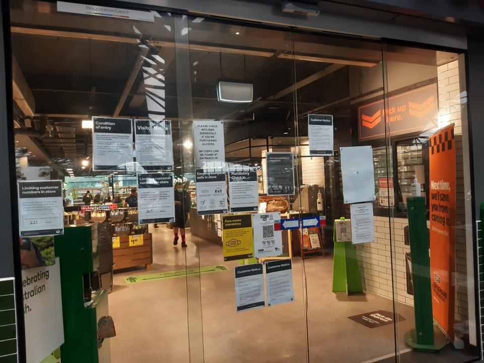 The sign placement on the sliding doors of a Woolworths Metro in Melbourne made it difficult for some people to sign in. Source: Twitter/@craig_halsall