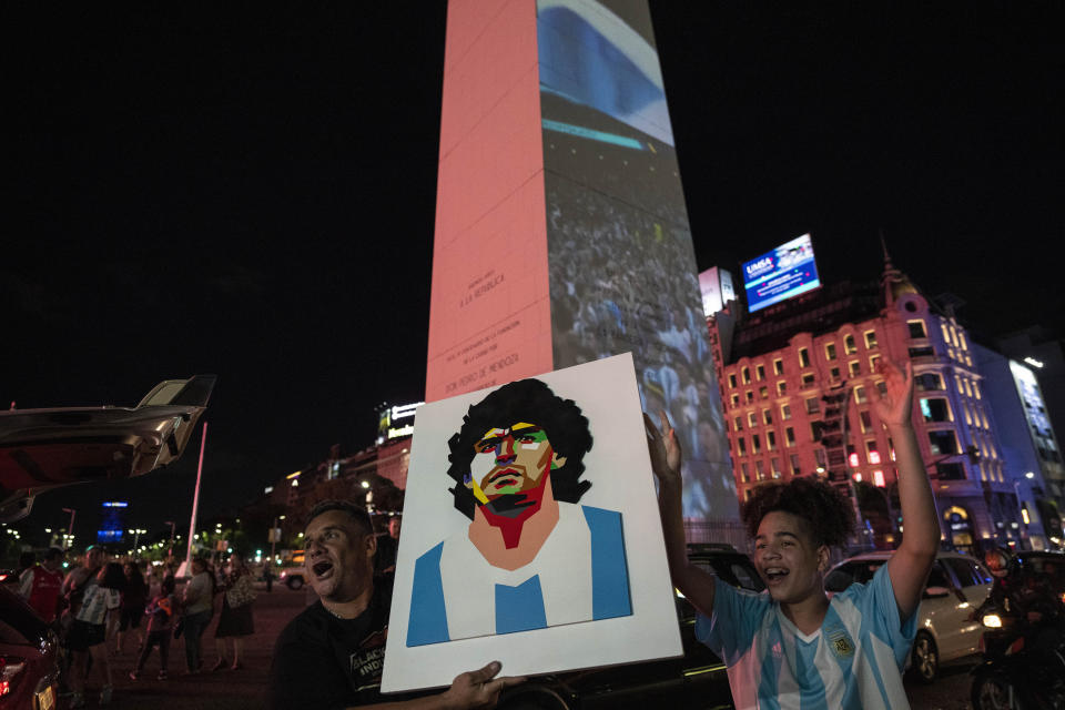 A soccer fan holds a poster depicting football legend Diego Maradona during a rally in support of the national soccer team, a day ahead of the World Cup final against France, in Buenos Aires, Argentina, Saturday, Dec. 17, 2022. (AP Photo/Rodrigo Abd)
