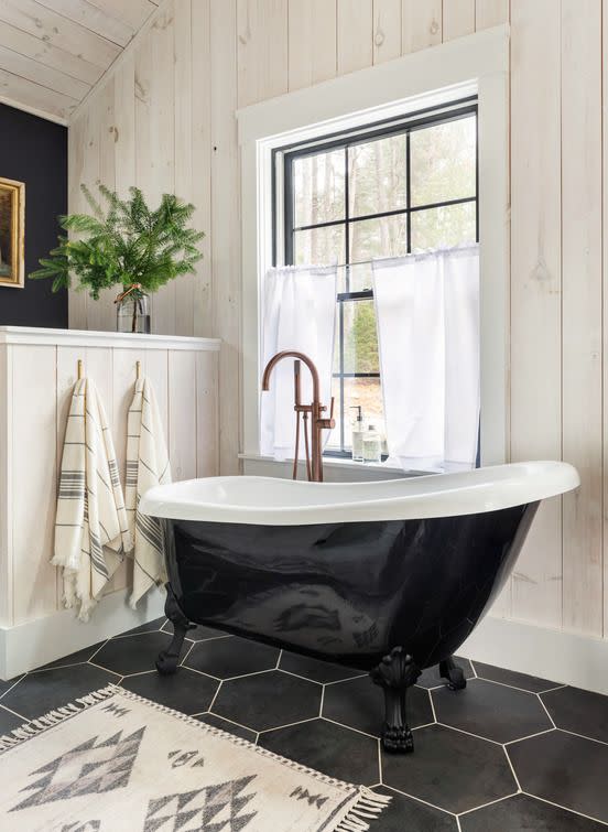 bathroom featuring black tile and black tub