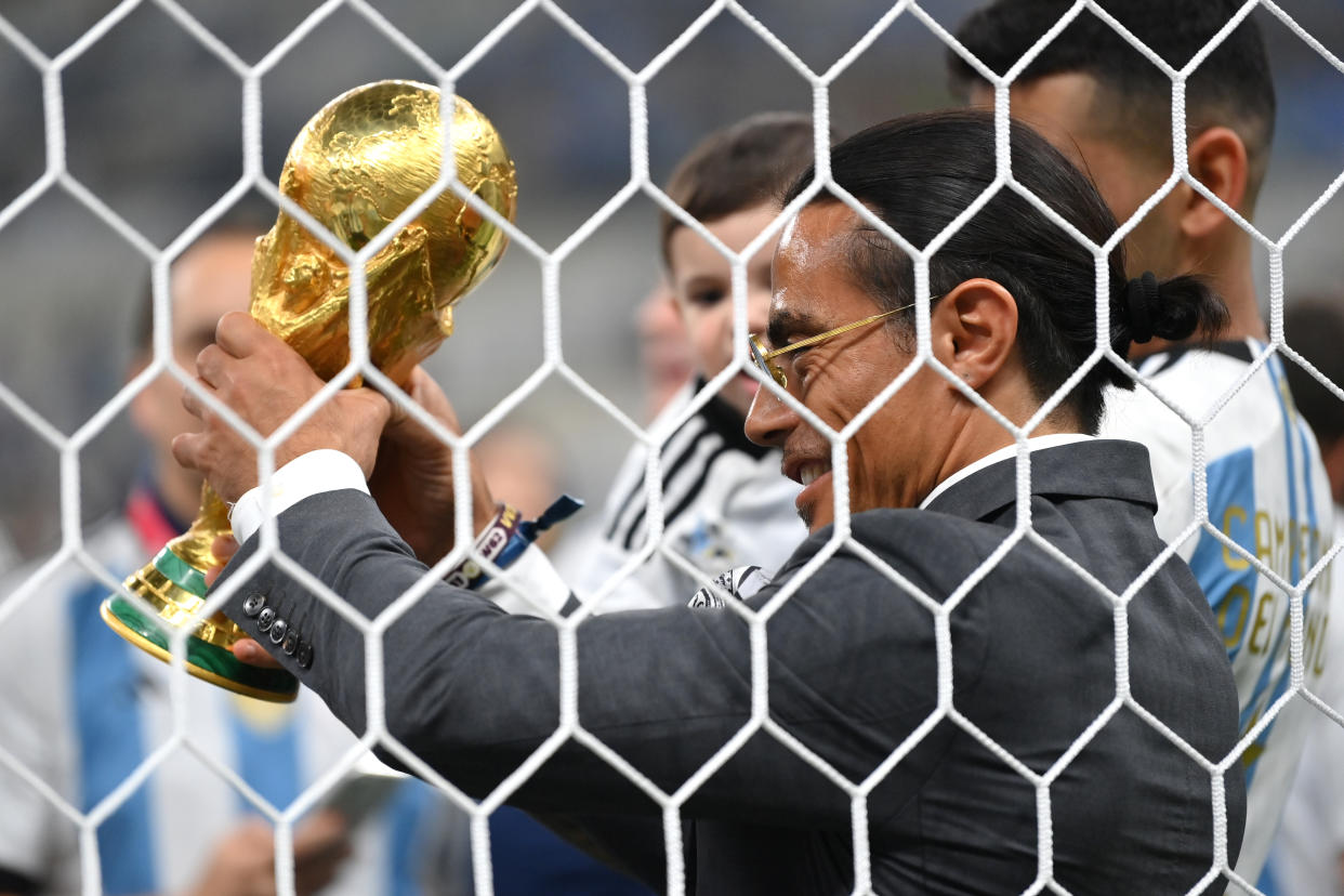 LUSAIL CITY, QATAR - DECEMBER 18: Nusret Goekce, nicknamed Salt Bae, admires the FIFA World Cup Qatar 2022 Winner's Trophy after the FIFA World Cup Qatar 2022 Final match between Argentina and France at Lusail Stadium on December 18, 2022 in Lusail City, Qatar. (Photo by Dan Mullan/Getty Images)