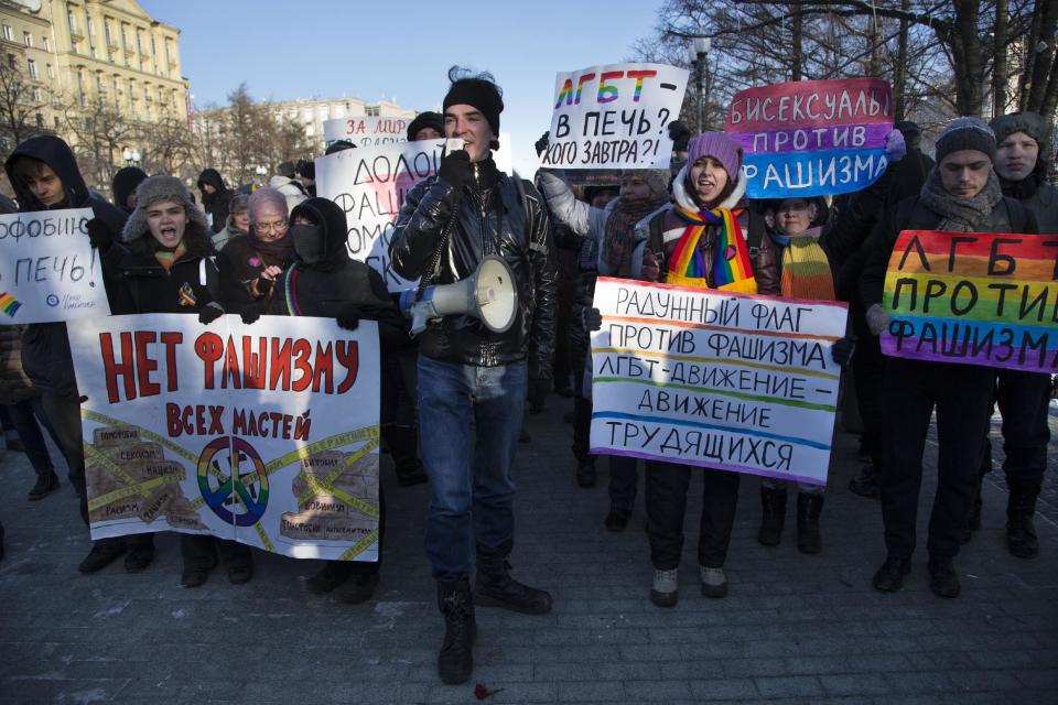 FILE - In this Sunday, Jan. 19, 2014 file photo Russian gay rights activists march along a Moscow boulevard in downtown. Slogans read: ' Down with all Kinds of Fascism', ' Homophobia into the Fire!', ' For Peace without Racism ! ', and 'Bisexuals Against Fascism'. When the Sochi Winter Olympics begin on Friday, Feb. 7, 2014, many will be watching to see whether Russia will enforce its law banning gay “propaganda” among minors if athletes, fans or activists wave rainbow flags or speak out in protest. The message so far has been confusing. (AP Photo/ Alexander Zemlianichenko)
