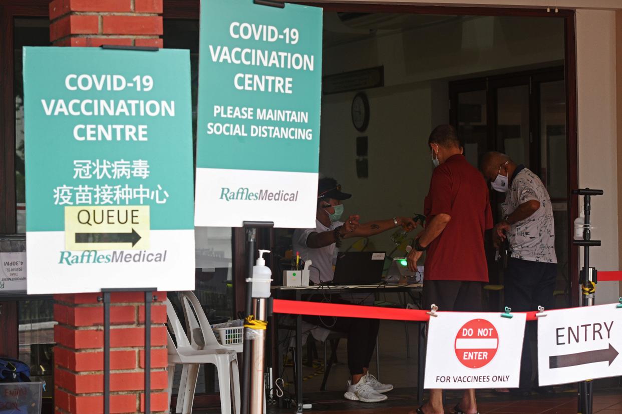 People register for COVID-19 vaccination at a vaccination center in Singapore on Oct. 7, 2021. Singapore reported 3,483 new cases of COVID-19 on Thursday, bringing the total tally in the country to 116,864. (Photo by Then Chih Wey/Xinhua via Getty Images)