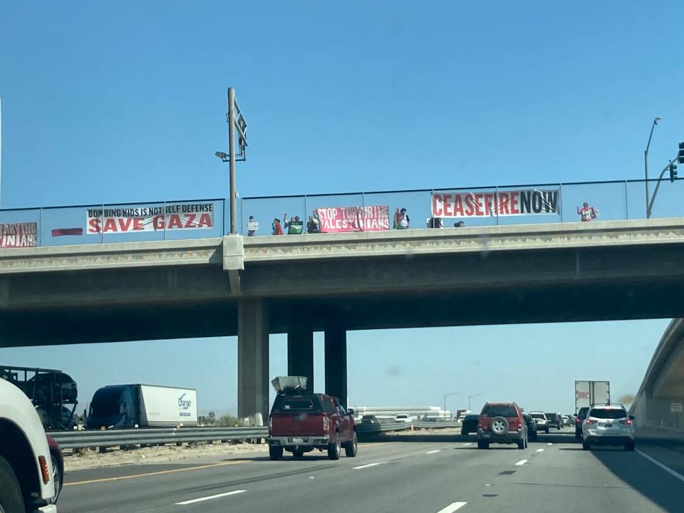 CODEPINK Coachella Valley staged multiple "banner drops" during a traffic jam on the opening day of the Coachella Valley Music and Arts Festival in Indio on Friday. The banners and signs, this one at the Cook Street exit of Interstate 10, demanded an end to the genocide of Palestinian people and calling for an immediate halt to U.S. arms support for Israel.