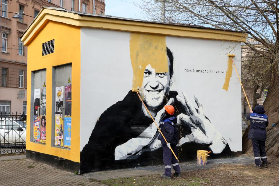 April 28, 2021:  Municipal workers paint over graffiti of Russia's imprisoned opposition leader Alexei Navalny in St. Petersburg, Russia. The words on the wall read "Hero of our time."