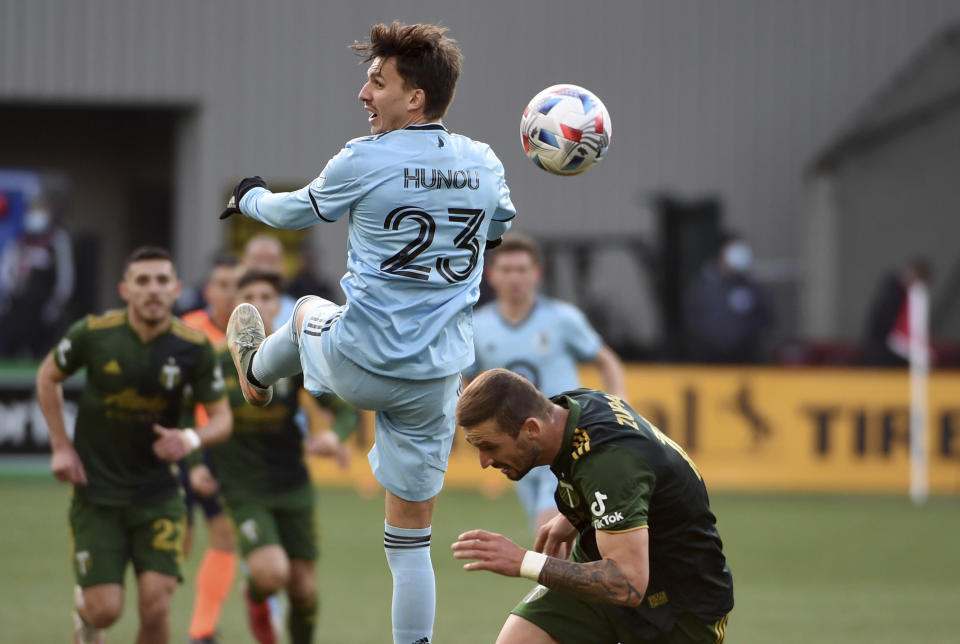 Minnesota United midfielder Adrien Hunou (23) heads a ball past Portland Timbers defender Dario Zuparic, right, during the first half of an MLS soccer match in Portland, Ore., Sunday, Nov. 21, 2021. (AP Photo/Steve Dykes)