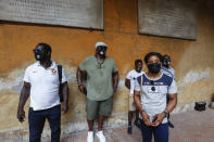 Freestyle wrestler Fatoumata Yarie Camara, of Guinea,foreground, pictured prior to receiving the COVID-19 vaccine at the Santo Spirito hospital in Rome, Saturday, July 3, 2021. In background, from left, United World Wrestling Development Officer Vincent Aka, of Ivory Coast, coach Alexis Rodriguez, of Cuba, and wrestlers Diamantino Fafe' and Augusto Midana, both from Guinea Bissau. A West African wrestler's dream of competing in the Olympics has come down to a plane ticket. Fatoumata Yarie Camara is the only Guinean athlete to qualify for these Games. She was ready for Tokyo, but confusion over travel reigned for weeks. The 25-year-old and her family can't afford it. Guinean officials promised a ticket, but at the last minute announced a withdrawal from the Olympics over COVID-19 concerns. Under international pressure, Guinea reversed its decision. (AP Photo/Riccardo De Luca)