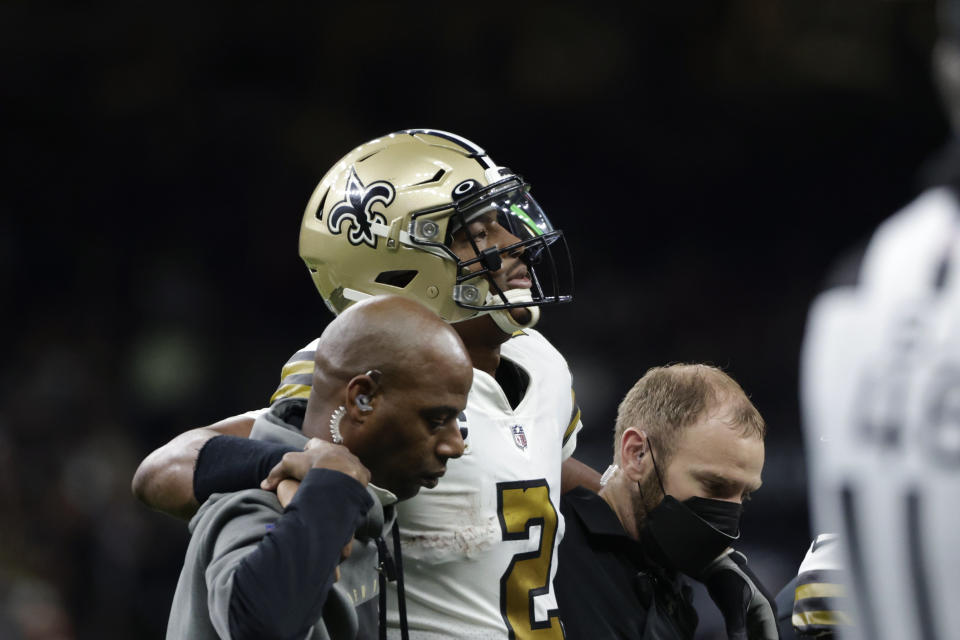 New Orleans Saints quarterback Jameis Winston (2) is helped off the field after being injured from a horse collar tackle in the first half of an NFL football game against the Tampa Bay Buccaneers in New Orleans, Sunday, Oct. 31, 2021. (AP Photo/Derick Hingle)