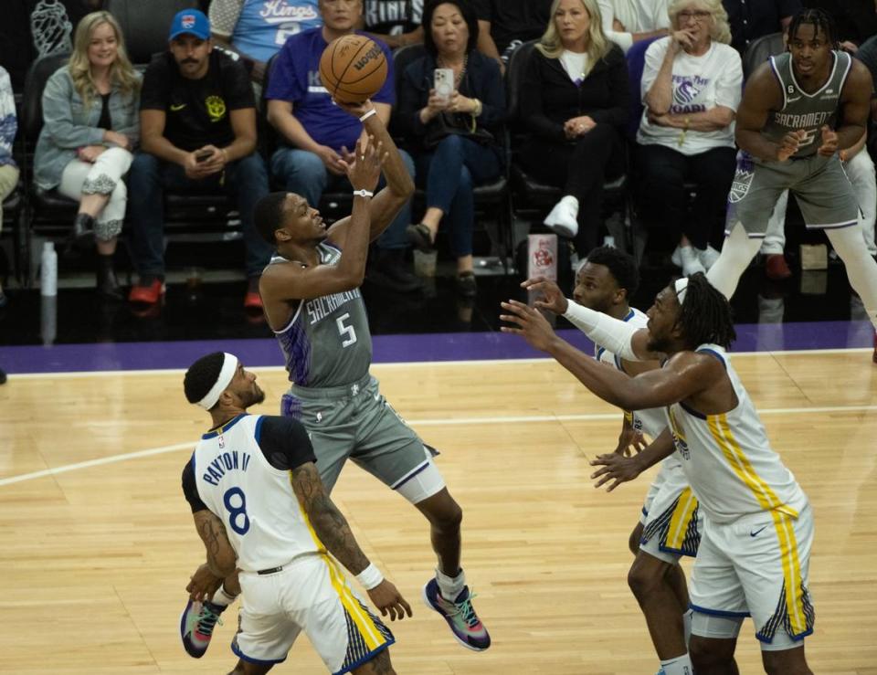 Sacramento Kings guard De’Aaron Fox (5) shoots over Golden State Warriors guard Gary Payton II (8), forward Kevon Looney (5) forward Andrew Wiggins (22) during Game 5 of the first-round NBA playoff series at Golden 1 Center on Wednesday.