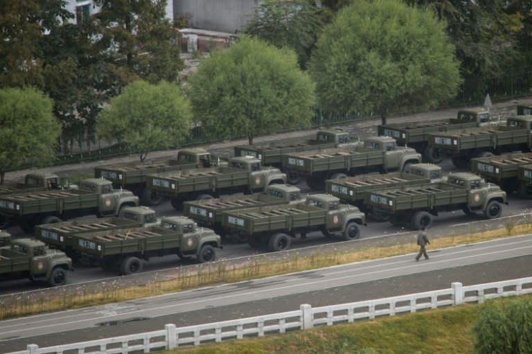 Empty military vehicles line up on a road in Pyongyang on October 10, 2015