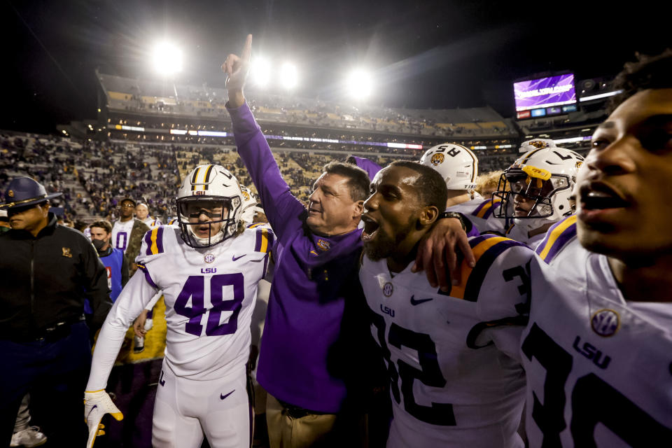 LSU head coach Ed Orgeron, center, celebrates with linebacker Sloan Wright (48) and cornerback Lloyd Cole (32) following a win over Texas A&M in an NCAA college football game in Baton Rouge, La., Saturday, Nov. 27, 2021. (AP Photo/Derick Hingle)