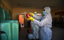 Disinfection team disinfect a classroom at Ivory Park Secondary School east of Johannesburg, South Africa, Thursday, May 28, 2020, ahead of the June 1, 2020, re-opening of Grade 7 and 12 learners to school.(AP Photo/Themba Hadebe)