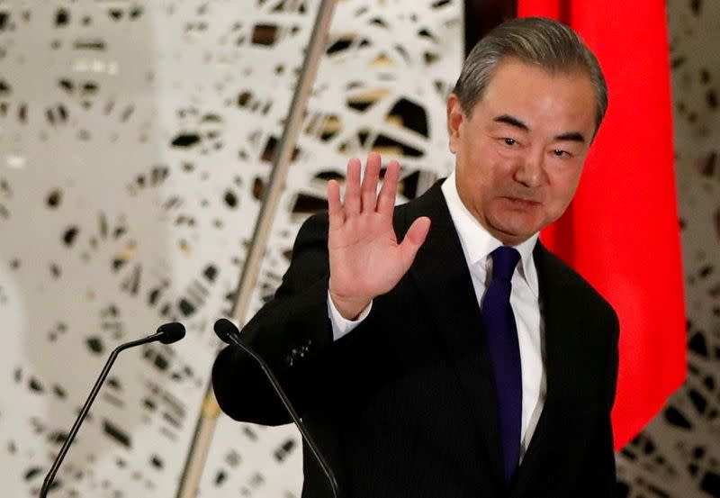 FILE PHOTO: China's State Councillor and Foreign Minister Wang Yi waves as he leaves a news conference in Tokyo, Japan