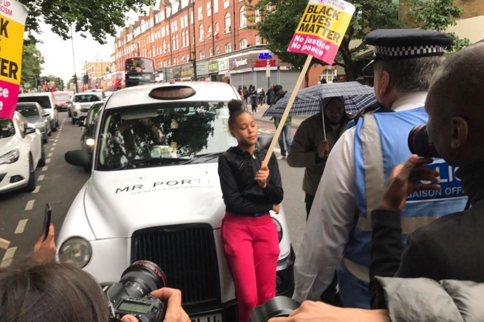 A woman blocking the path of a taxi.