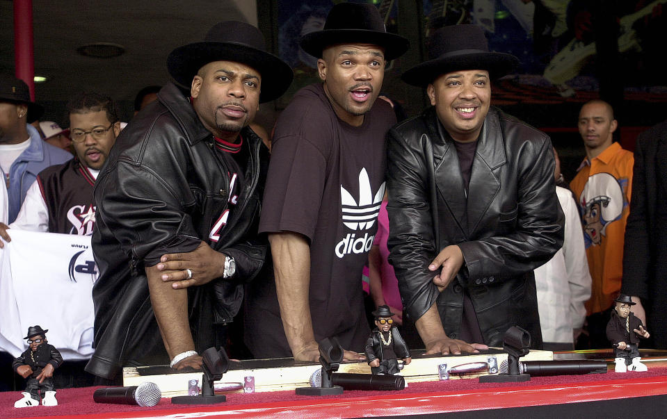 FILE - Hip hop pioneers RUN-DMC create handprints in cement as they are inducted into Hollywood's RockWalk, Feb. 25, 2002, in Los Angeles. The signs of hip-hop’s influence are everywhere — but it didn't start out that way. Even though the company had seen an unusual spike in sales of its Superstar shoes in the Northeast in 1986, it wasn't ready to attribute that to Run-D.M.C. and their hit “My Adidas.” When company execs saw the group ask fans to show off their Adidas and thousands removed their shoes and waved them in the air at a Madison Square Garden performance, they were sold. They signed the rap group to a $1 million deal that resulted in their own shoe line in 1988. (AP Photo/Krista Niles)
