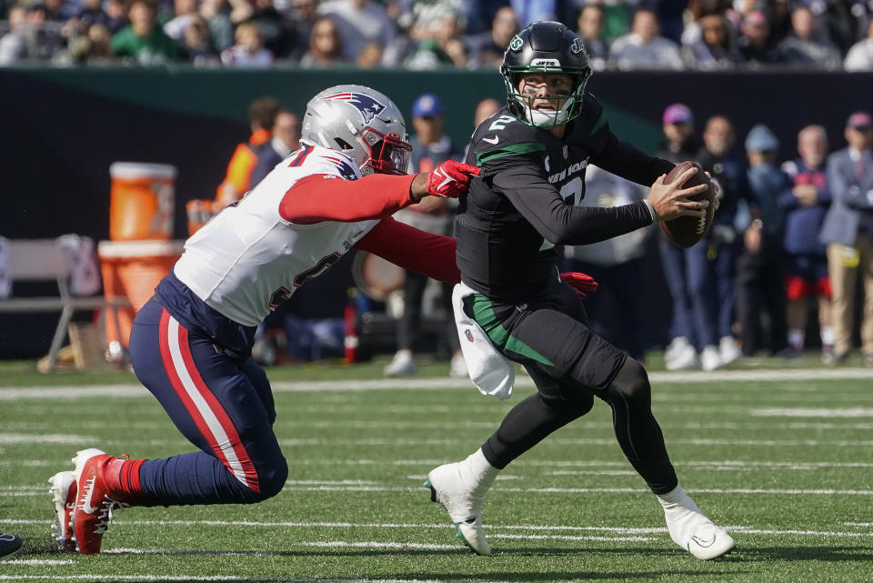 New York Jets quarterback Zach Wilson (2) avoids a tackle from New England Patriots linebacker Matthew Judon (9) during the first quarter of an NFL football game, Sunday, Oct. 30, 2022, in New York. (AP Photo/John Minchillo)