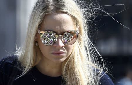 Floral tributes are reflected in a woman's sunglasses as she views tributes in Parliament Square following the attack in Westminster earlier in the week, in central London, Britain March 26, 2017. REUTERS/Neil Hall