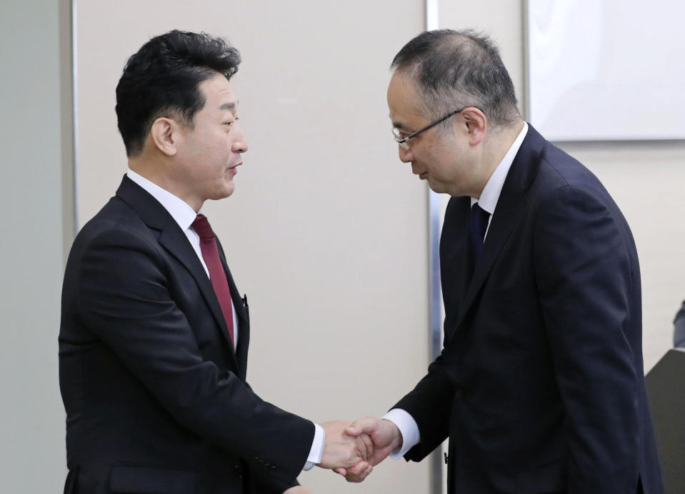 Lee Ho-hyeon, left, director-general for International Trade Policy at South Korea's Trade, Industry and Energy Ministry, shakes hands with Yoichi Iida, director-general of Japan's Trade Control Department before a director-general level meeting at the trade ministry in Tokyo Monday, Dec. 16, 2019. Senior officials from Japan and South Korea were holding talks Monday on high-tech exports for the first time since Tokyo tightened controls on South Korean semiconductor parts earlier this year. (Kyodo News via AP)