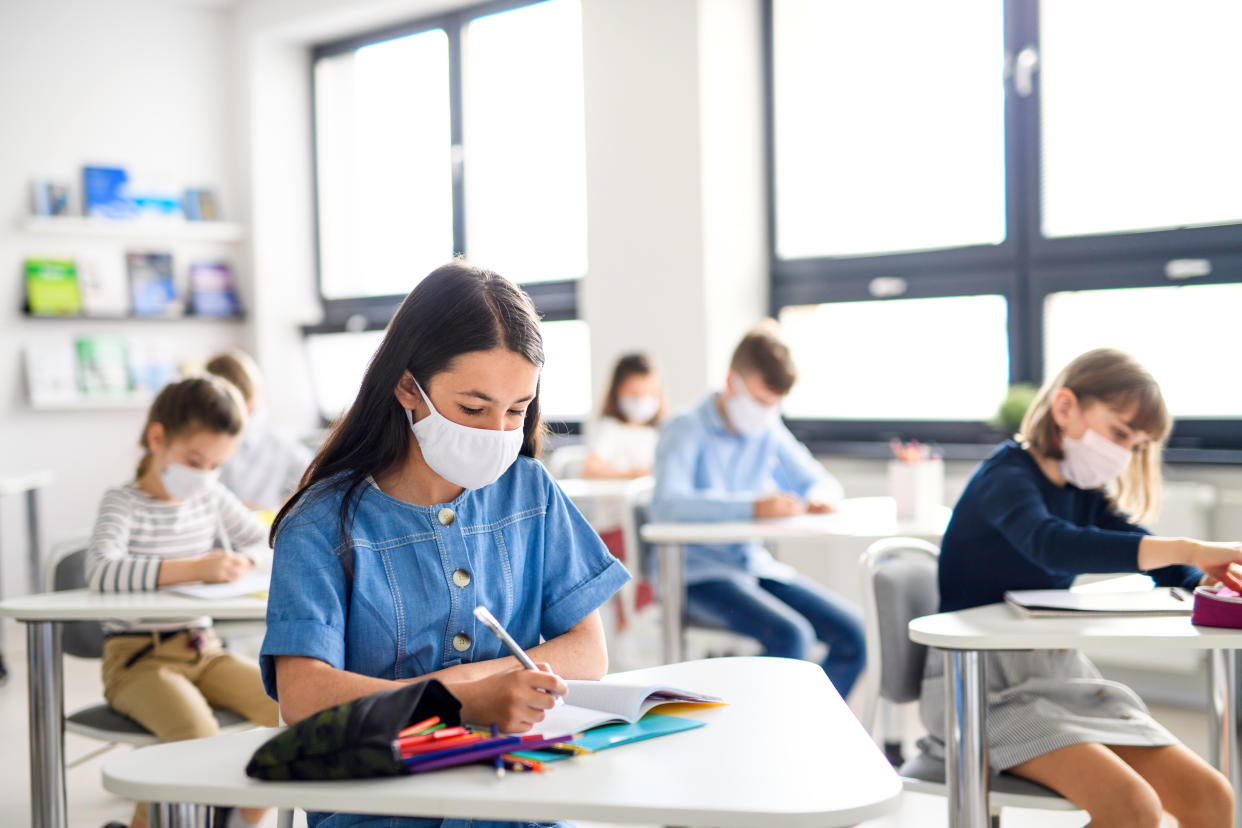 Small children with face mask back at school after covid-19 quarantine and lockdown.