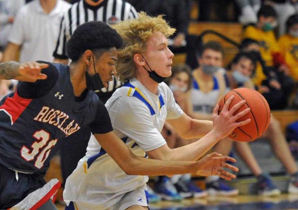 Hull's Tommy Burke, right, passes as Rockland's Tremaine Perryman, left, defends during boys basketball at Hull High School, Thursday, Feb. 3, 2022.