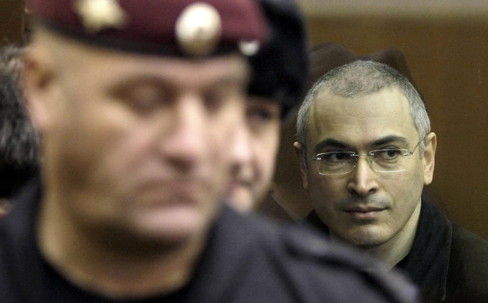 FILE - Mikhail Khodorkovsky, right, is escorted to a courtroom in Moscow, Russia, Wednesday, Dec. 29, 2010. Khodorkovsky, once Russia’s richest man, posed a challenge to Vladimir Putin early in his presidency but later was convicted of economic crimes seen as revenge for his political ambitions. (AP Photo/Misha Japaridze, File)