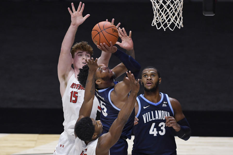 Hartford's Moses Flowers, bottom, fouls Villanova's Justin Moore during the first half of an NCAA college basketball game Tuesday, Dec. 1, 2020, in Uncasville, Conn. (AP Photo/Jessica Hill)