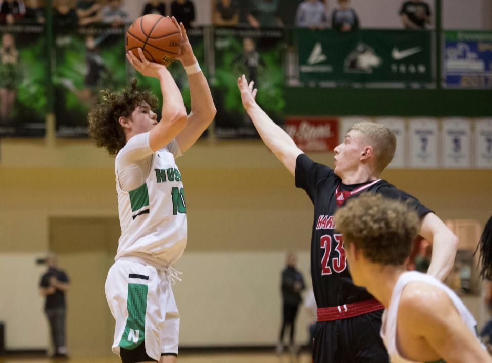 North’s Brayden Huebner (10) takes a shot over Harrison’ s Shane Sims (23) as the North Huskies play the Harrison Warriors during the IHSAA Class 4A Sectional championship game at North High School Saturday, March 5, 2022. 