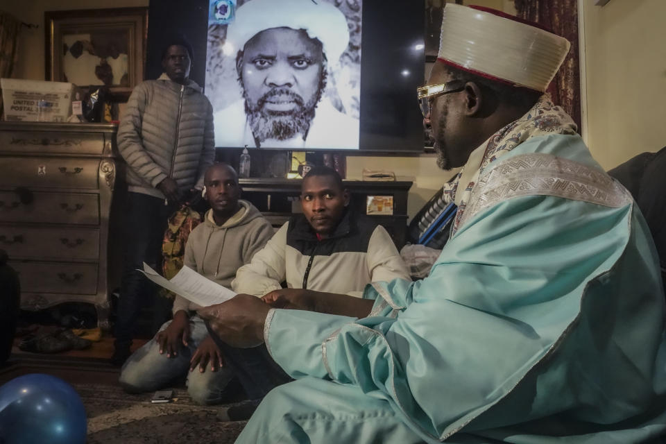 Imam Omar Niass, far right, advises migrants from Senegal, on how to apply for city services at Bronx's Masjid Ansaru-Deen mosque, Friday March 15, 2024, in New York. Imam Niass has repurposed the mosque, formerly his family home, as a refuge and shelter for African migrants seeking asylum in the United States. (AP Photo/Bebeto Matthews)