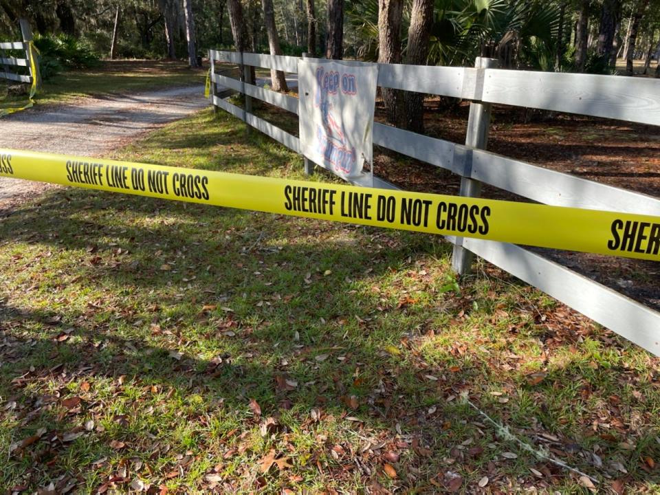 A yellow crime scene marker is used to block the entrance of a property in Orange Springs that was the site of a fatal shooting on Monday night.