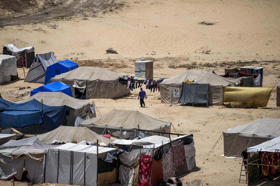 A Palestinian man displaced by the Israeli bombardment of the Gaza Strip, walks at a makeshift tent camp in Khan Younis, southern Gaza Strip, Thursday, July 4, 2024. Over nine months of war between Israel and Hamas, Palestinian families in Gaza have been uprooted repeatedly, driven back and forth across the territory to escape the fighting. Each time has meant a wrenching move to a new location and a series of crowded, temporary shelters. (AP Photo/Abdel Kareem Hana)