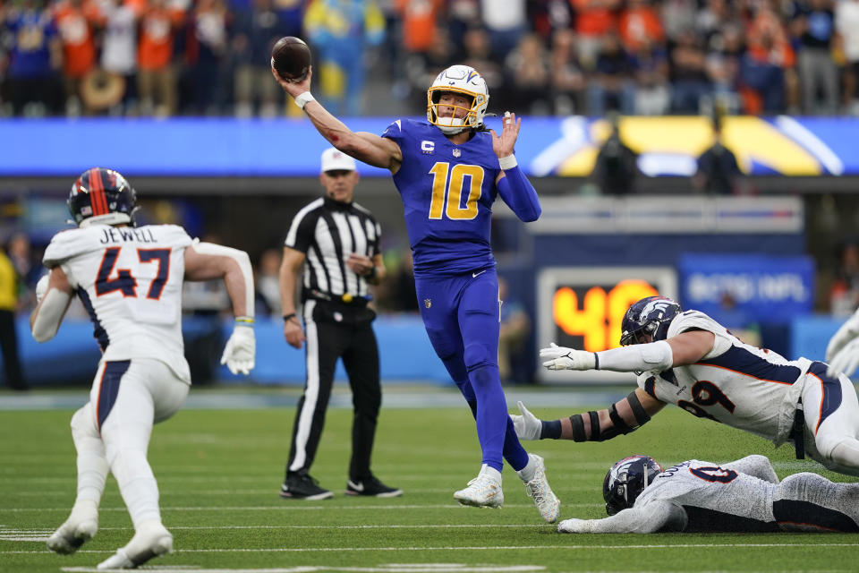 Los Angeles Chargers quarterback Justin Herbert (10) throws under pressure during the first half of an NFL football game against the Denver Broncos, Sunday, Dec. 10, 2023, in Inglewood, Calif. (AP Photo/Ryan Sun)
