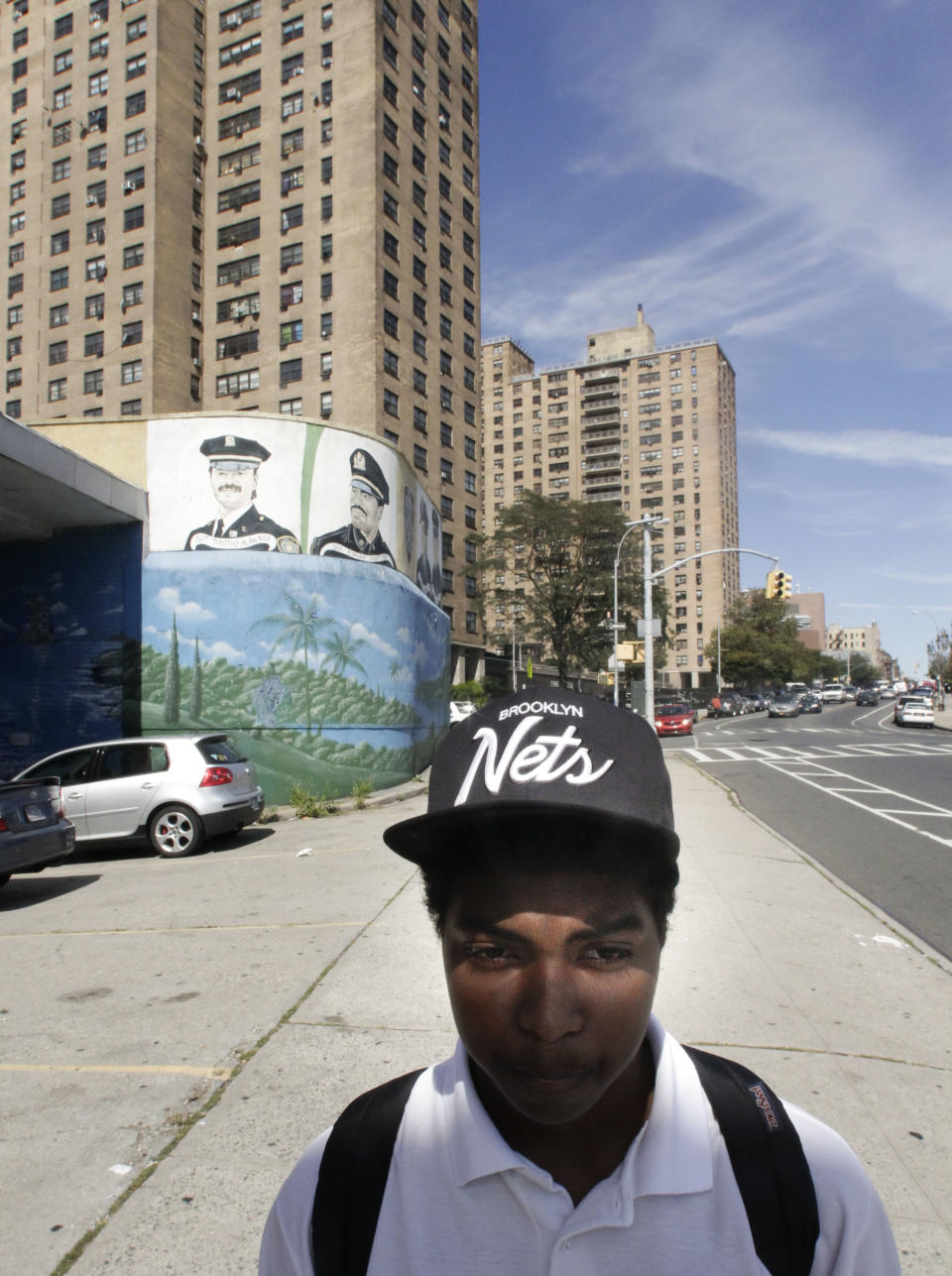 Jerome Stewart, 15, wears a Brooklyn Nets cap as he walks home from school past the Ebbets Field Apartments, home of the former Brooklyn Dodgers, on Wednesday, Sept. 19, 2012 in Brooklyn, N.Y. "I used to be a Knicks fan" said Stewart, "but switched to the Nets." After decades without a professional sports team after the Dodgers moved west, Brooklyn is hitting the major leagues again with a new arena and the Brooklyn Nets' basketball franchise. (AP Photo/Bebeto Matthews)