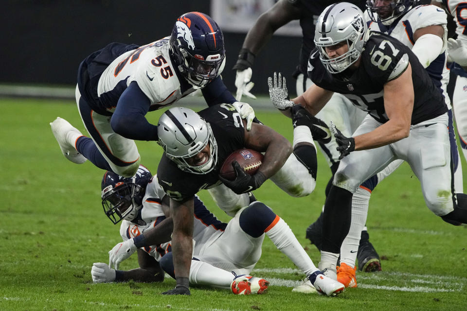 Las Vegas Raiders running back Josh Jacobs (28) dives for a gain against Denver Broncos outside linebacker Bradley Chubb (55) during the second half of an NFL football game, Sunday, Dec. 26, 2021, in Las Vegas. (AP Photo/Rick Scuteri)